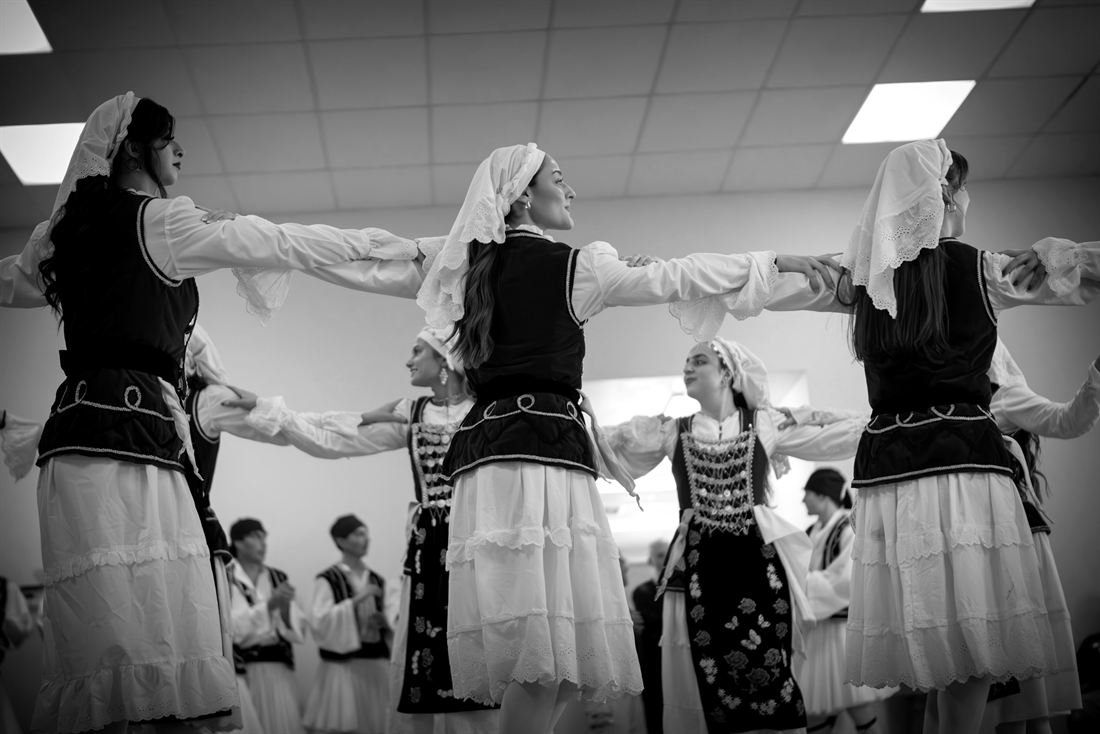 Frauen in griechischer Tracht tanzen Hand in Hand im Kreis, Schwarz-Weiß