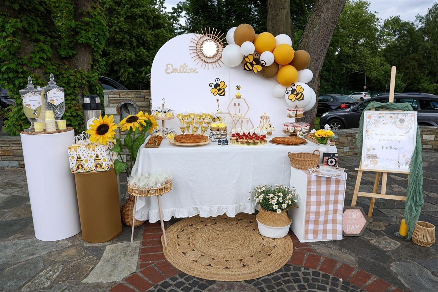 Taufdekoration im Bienen-Stil mit Ballonbogen, Sonnenblumen und Sweet-Table im Freien