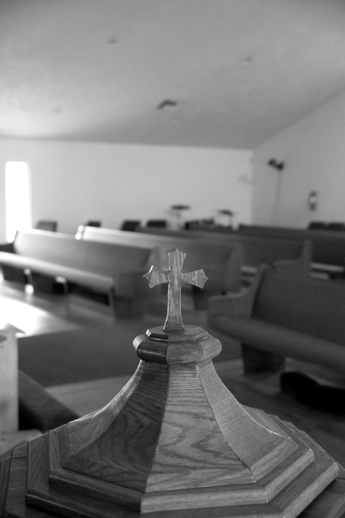 Holzkreuz in der Kirche vor den Bankreihen, Schwarz-Weiß